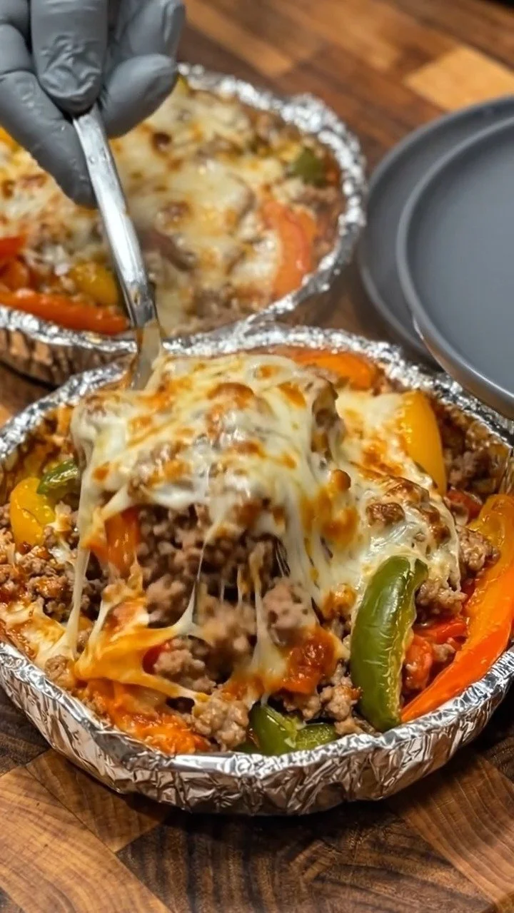 Cheesy baked stuffed pepper bowls filled with rice, cheese, and vegetables.