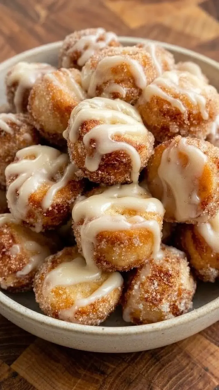 A plate of fluffy cinnamon sugar donut holes, dusted with sweet cinnamon sugar.