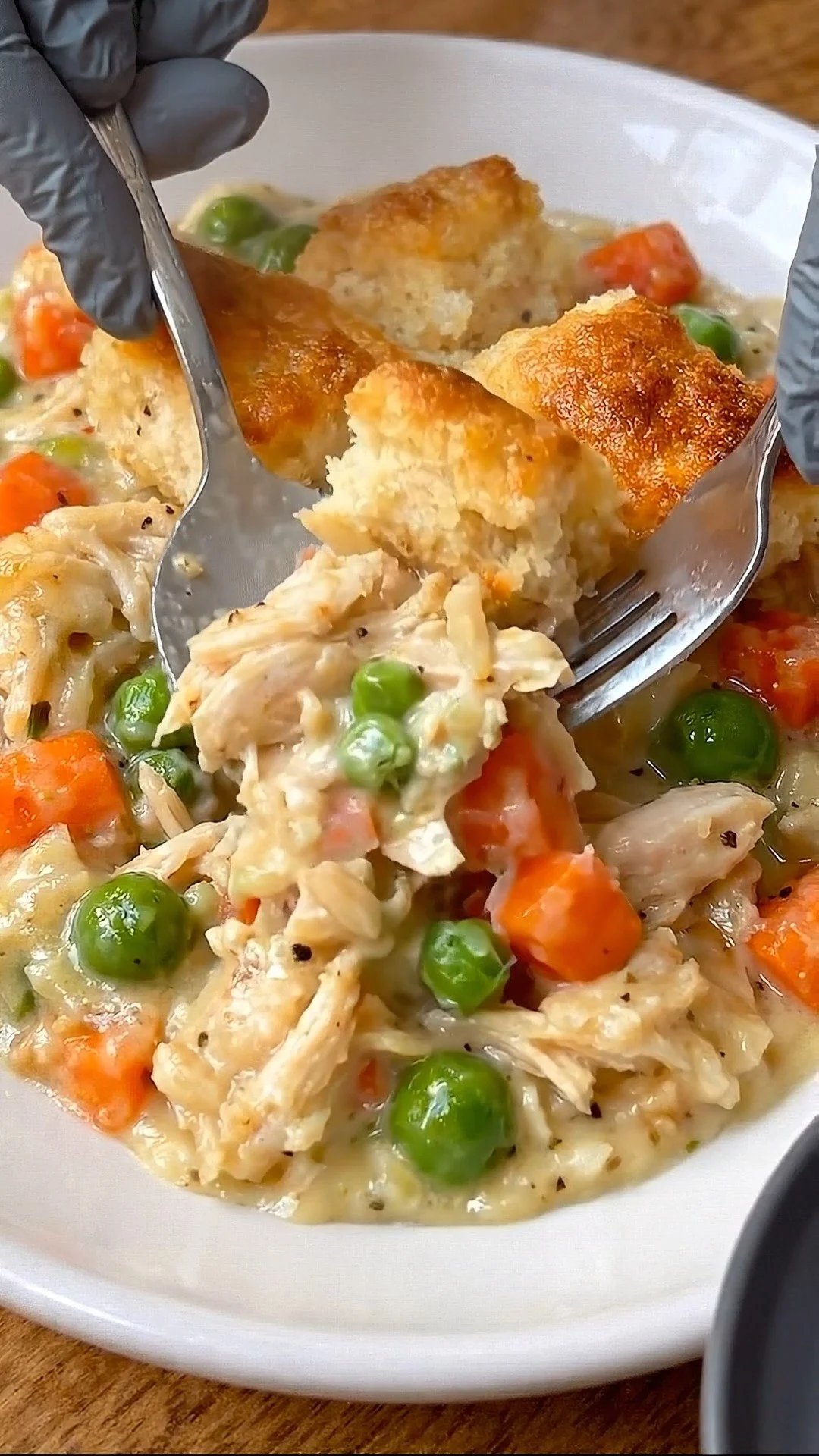 Creamy chicken pot pie bowl with chicken, vegetables, and flaky crust.