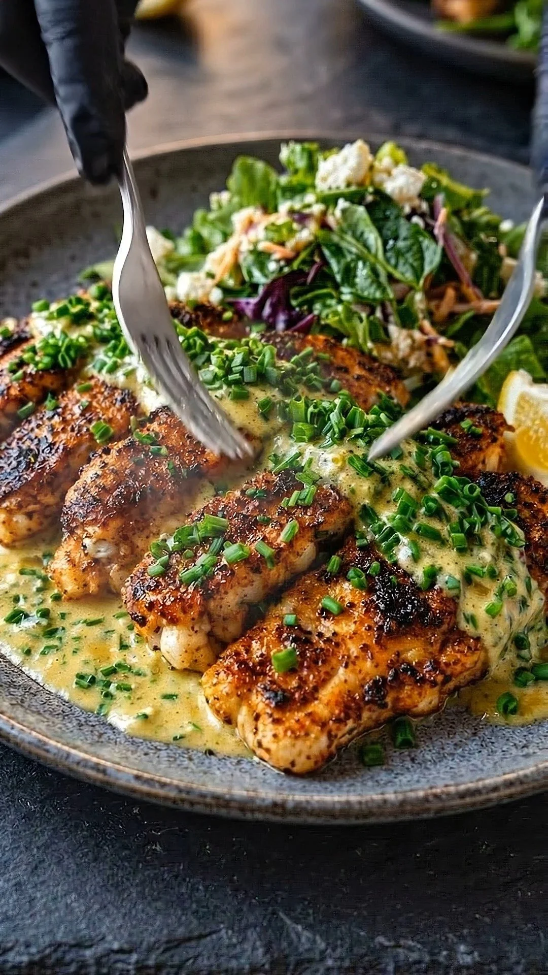 Crispy blackened tilapia served with garlic-herb sauce on a plate
