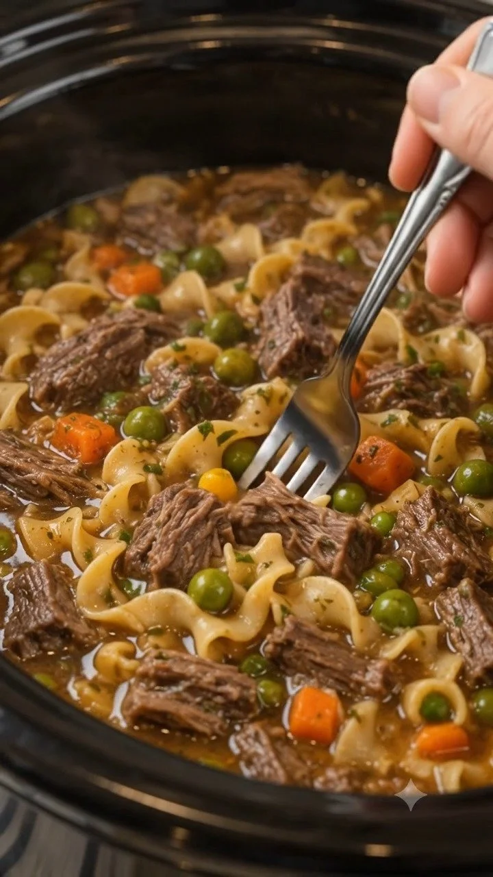 Crockpot Beef and Noodles served in a bowl with fresh herbs on top