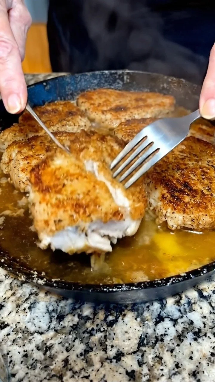 Juicy and perfectly cooked pork chops on a plate with herbs and spices