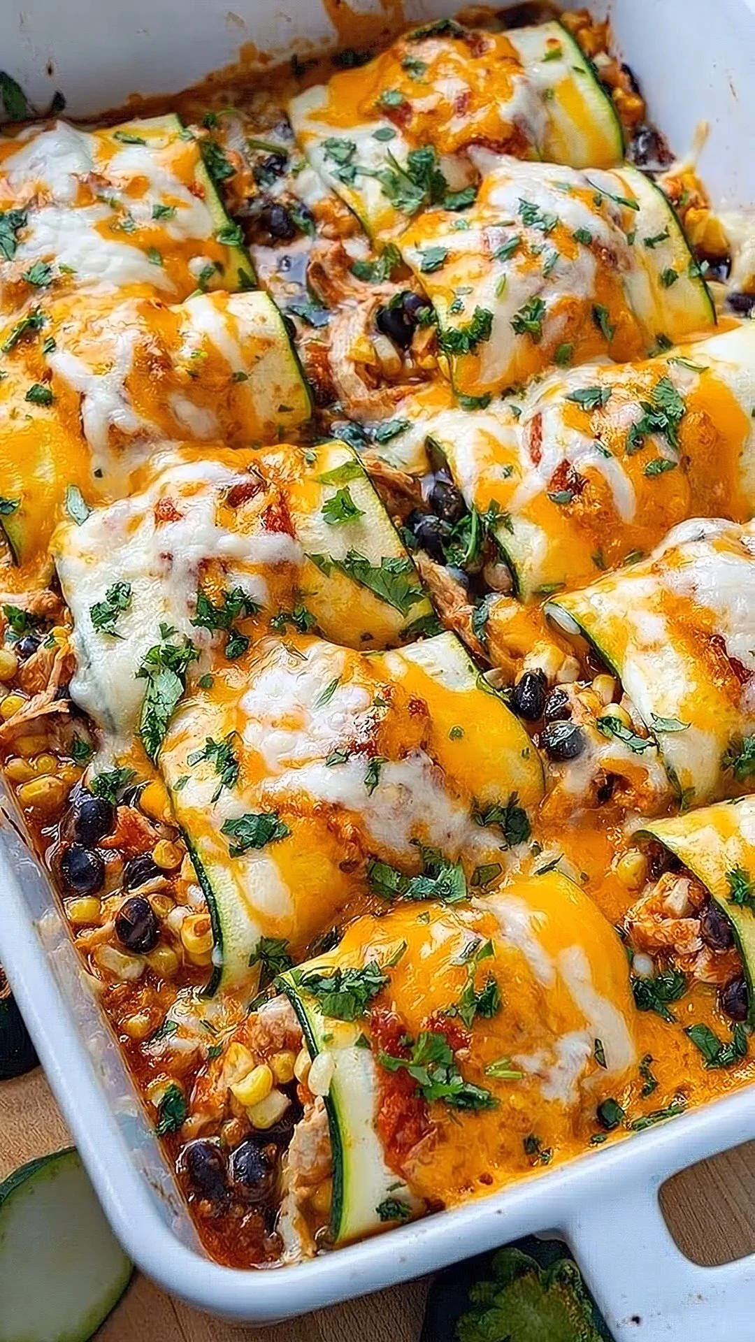 Delicious Zucchini Chicken Enchiladas topped with cheese and fresh herbs.