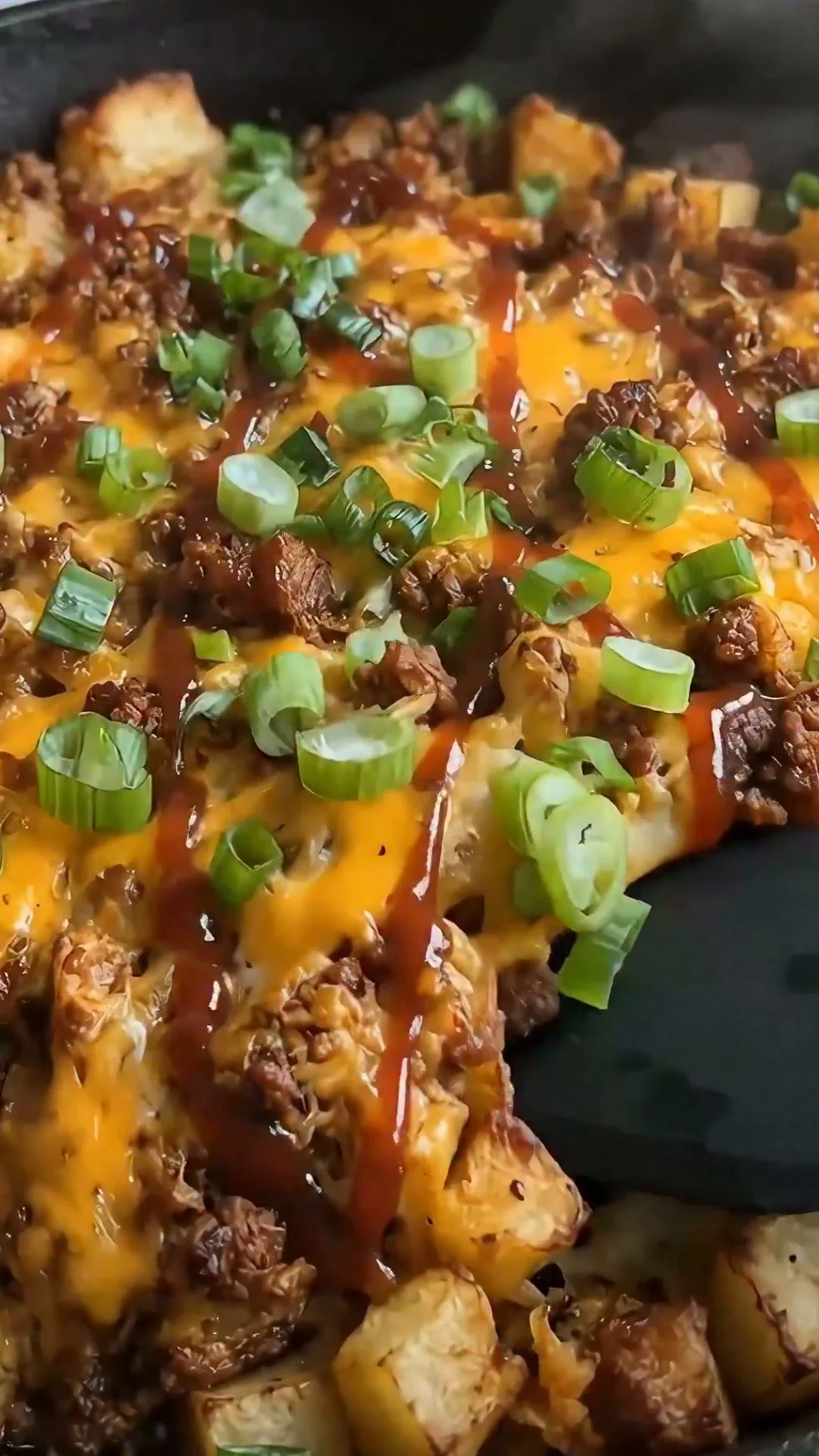 Loaded Potato Beef Skillet with beef, potatoes, and toppings in a cast iron skillet